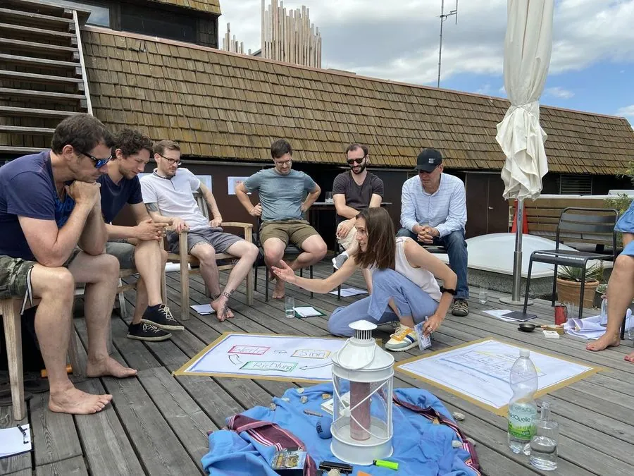 Klausur des myblock-Teams auf einer Dachterrasse, Arbeitsblätter auf dem Boden.