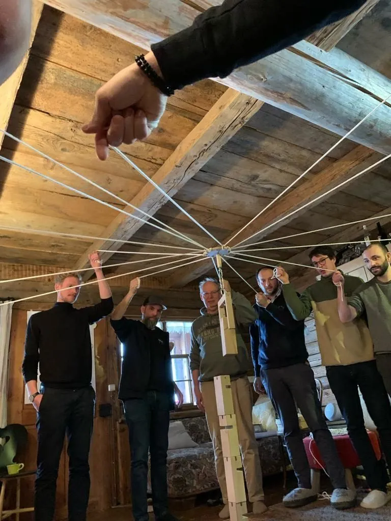 Teamtag auf der Alphütte: Übung mit gespannten Seilen unter der Holzdecke.