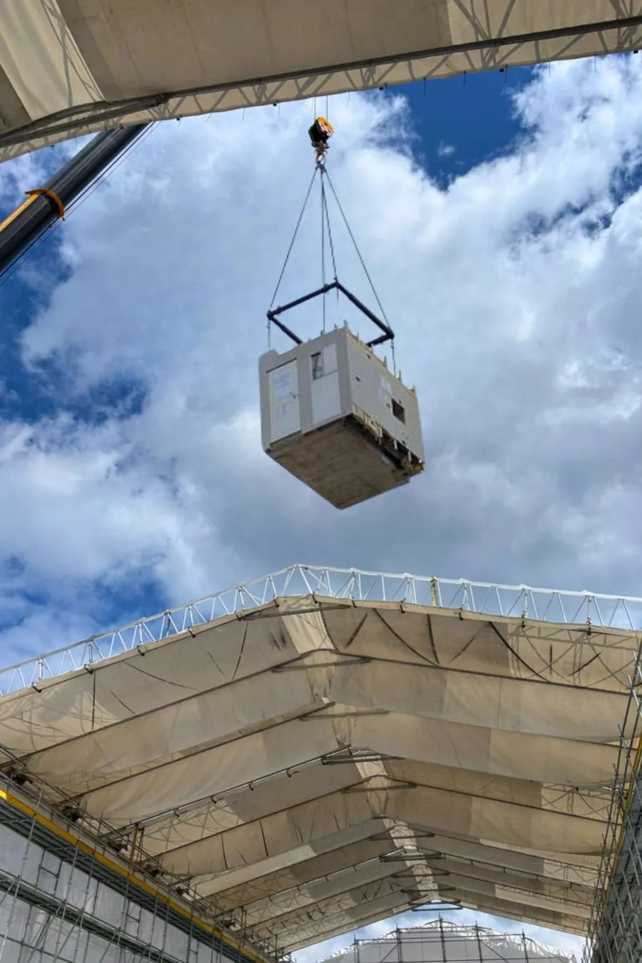 Techniksystem am Kran über dem Wetterschutzdach einer Baustelle.